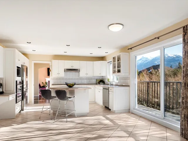 Kitchen featuring a breakfast bar area, stainless steel appliances, glass insert cabinets, backsplash, and a center island