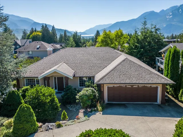 Single story home featuring a mountain view, an attached garage, concrete driveway, and a shingled roof