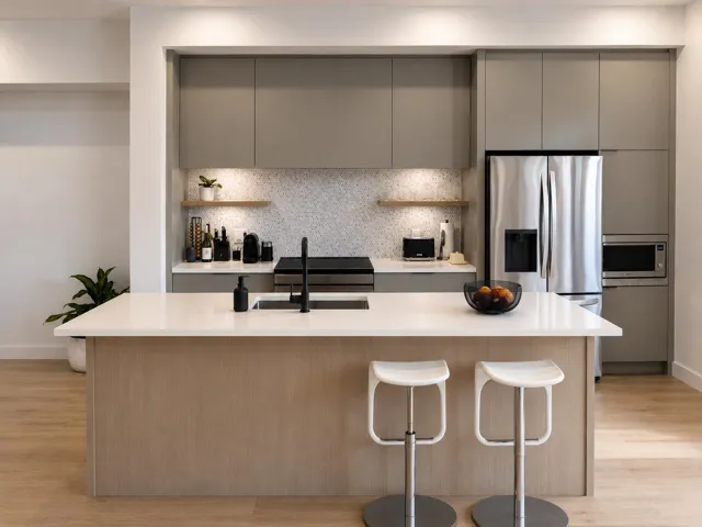 Kitchen featuring a substantial island with a light countertop, integrated sink, and matte black faucet