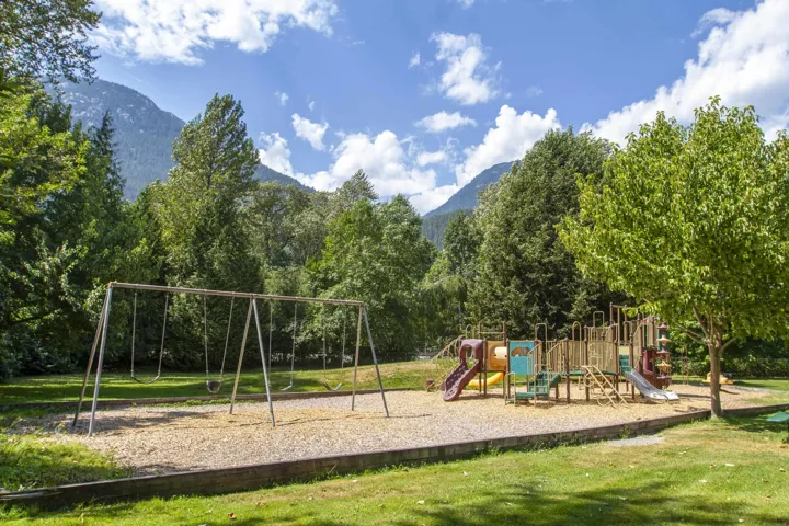 Communal playground with a mountain view and a yard