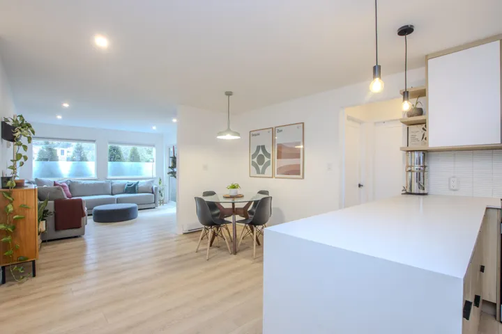 Kitchen with hanging light fixtures, light wood-style floors, open shelves, a peninsula, and open floor plan