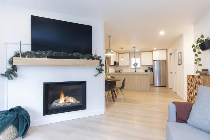 Living area with light wood-style floors, a glass covered fireplace, and recessed lighting