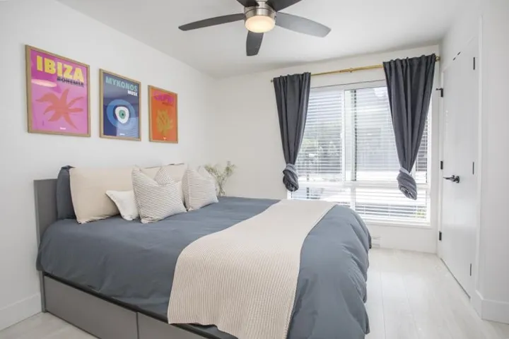White walls, light wood-finish flooring, and a ceiling fan with integrated lighting