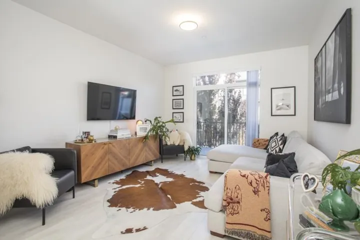 Recessed ceiling lighting, wood-finish flooring, and a sliding glass door to a balcony