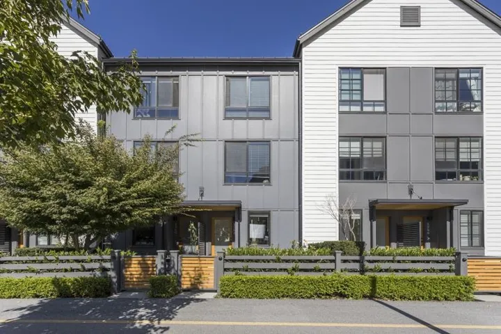 Modern architectural design featuring multi-pane windows and a wood-slat fence with integrated shrubbery