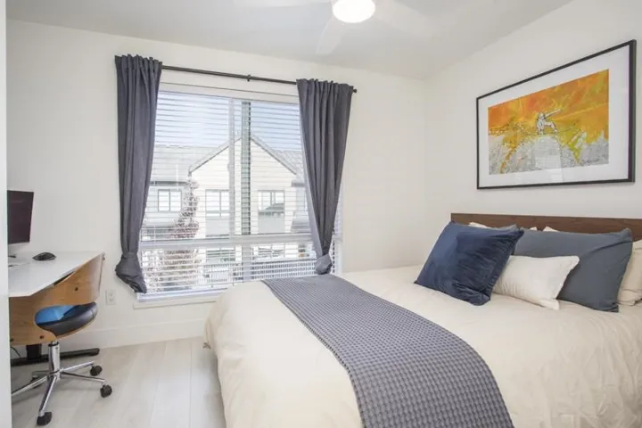 Window with blinds and drapes, light-toned wood-finish flooring, white walls, and a ceiling fan