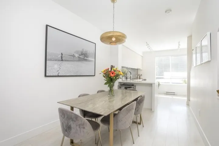 Open-concept dining area with wood-finish flooring, a contemporary pendant light fixture, and track lighting