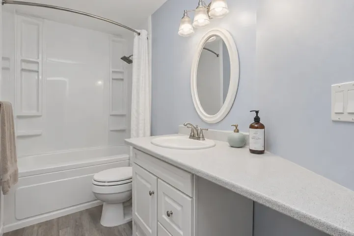 Bathroom featuring a white vanity with panel cabinetry and a speckled countertop