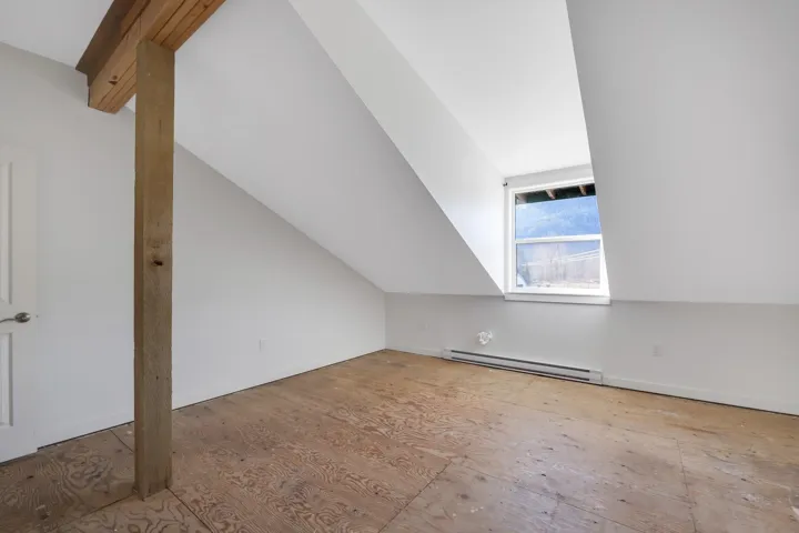 Bonus room with a baseboard heating unit and lofted ceiling