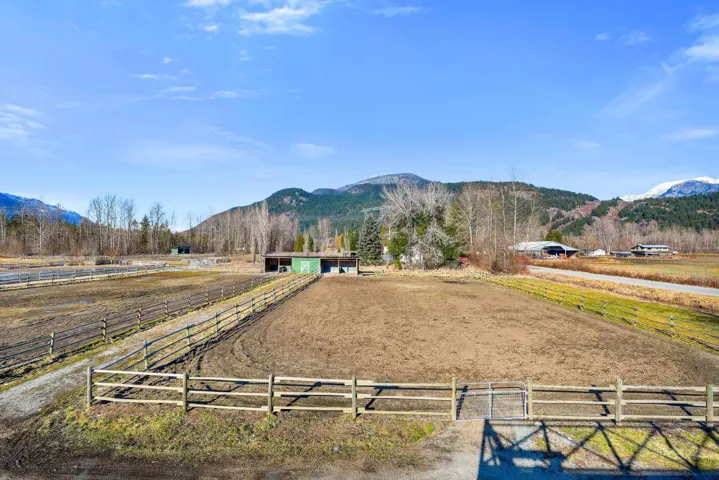 View of yard featuring an enclosed horse arena, a mountain view, and a rural view