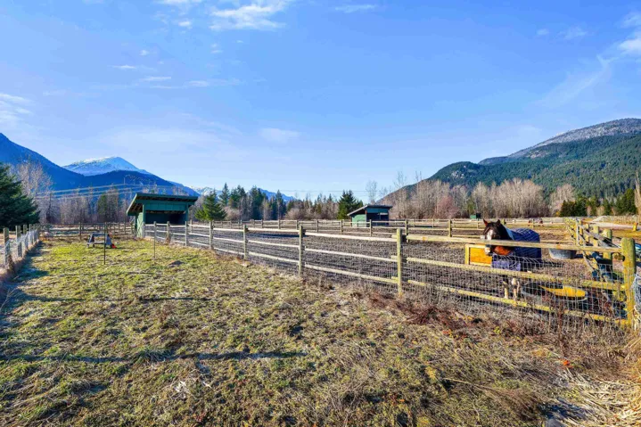 View of yard featuring an outbuilding, a mountain view, a view of rural / pastoral area, an exterior structure, and an enclosed riding area