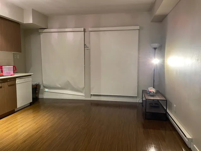 Interior space with dishwasher, dark wood-type flooring, light countertops, a baseboard heating unit, and modern cabinets