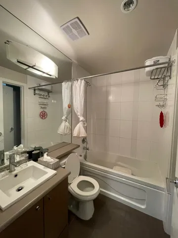 Bathroom featuring vanity, shower / bath combo with shower curtain, and tile patterned flooring