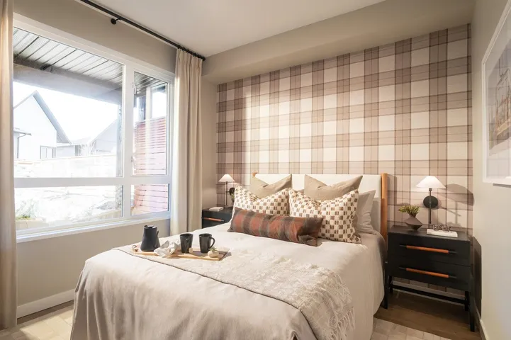 Bedroom with wallpapered walls, an accent wall, and light wood-type flooring