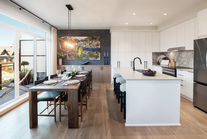 Kitchen with freestanding refrigerator, white cabinets, modern cabinets, decorative backsplash, and an island with sink