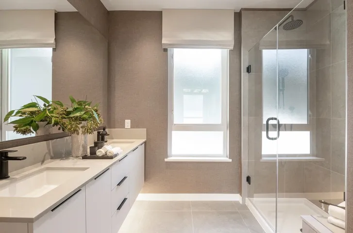 Full bath featuring double vanity, a shower stall, and light tile patterned flooring