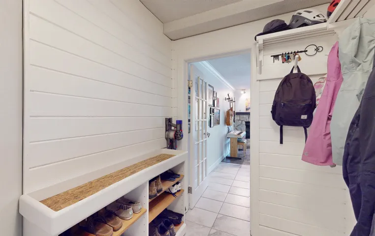 Mudroom featuring light tile patterned flooring, french doors, and wooden walls
