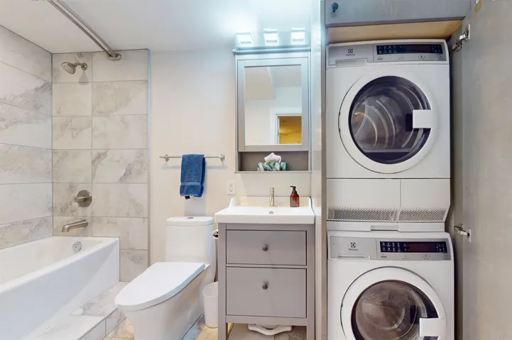 Washroom with stacked washer and clothes dryer