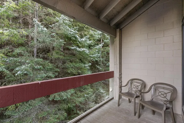 Kitchen with white appliances, ventilation hood, brown cabinetry, dark countertops, and decorative backsplash
