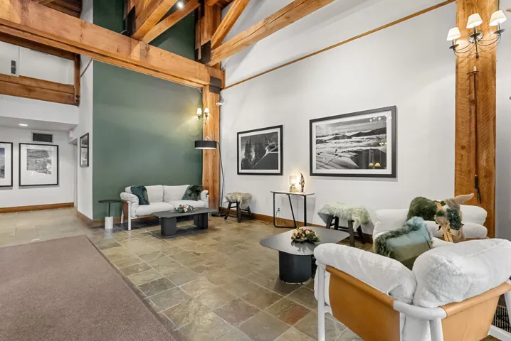 Common area with a towering ceiling and beam ceiling