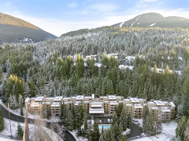 Carpeted living room featuring a wood ceiling with exposed beams and track lighting
