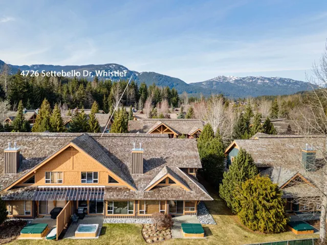 Mountain-style architecture featuring multiple pitched roofs, wood siding, and prominent chimneys