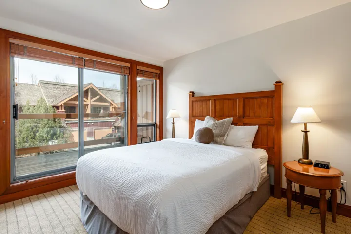 Bedroom featuring wood-frame glass sliding doors opening to an exterior balcony