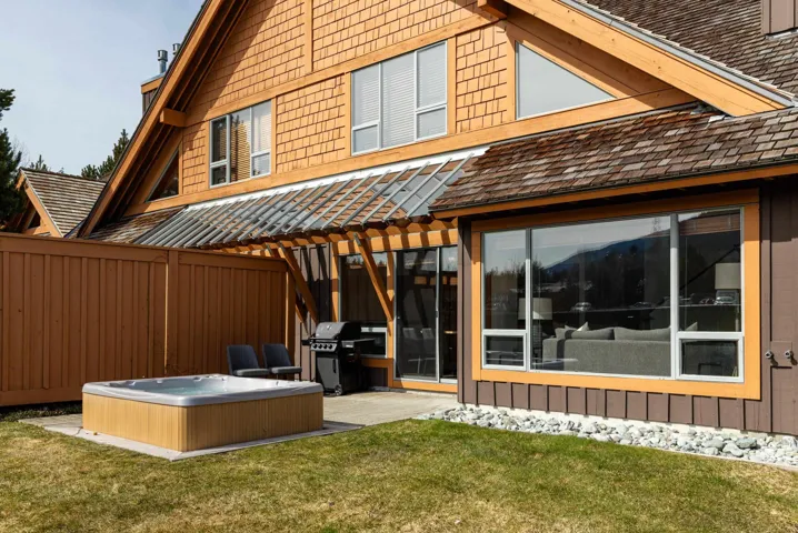 Private outdoor spa area featuring a built-in hot tub, concrete patio, and slatted wood privacy fencing