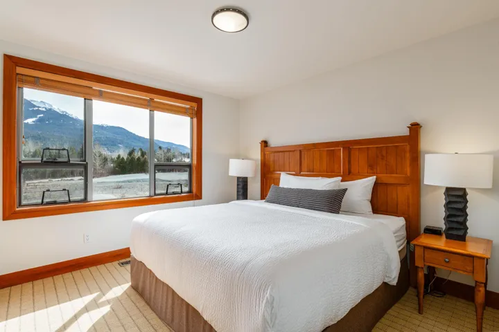 Bright interior with wood-finish window trim and a panoramic mountain vista