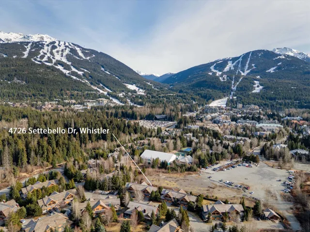 Aerial perspective showcasing the property's setting amidst a mountainous landscape with snow-capped peaks
