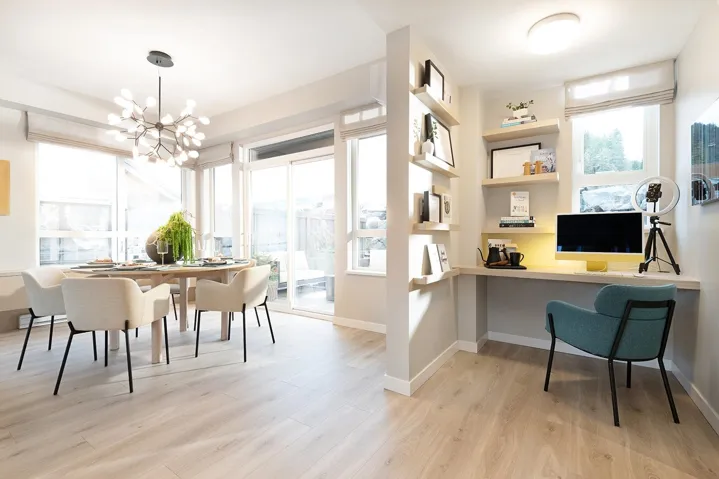 Dining room with built in study area, light wood finished floors, and hanging lights