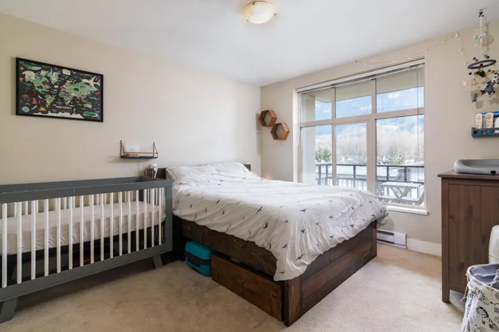 Carpeted bedroom with a baseboard radiator and baseboards