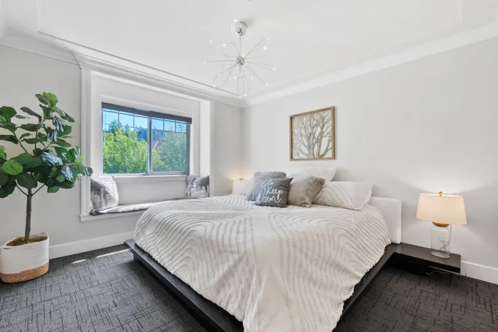 Spacious room featuring patterned carpeting, recessed lighting, a window with exterior visibility, and a ceiling-mounted speaker