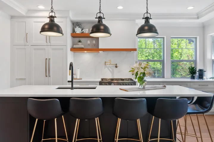 Living space featuring a vaulted ceiling with exposed beams, wood-finish flooring, and a large window