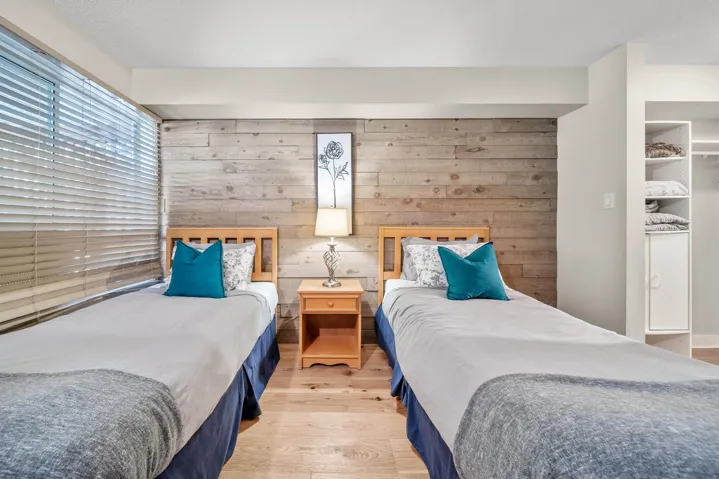 Bedroom with light wood-style flooring and wooden walls