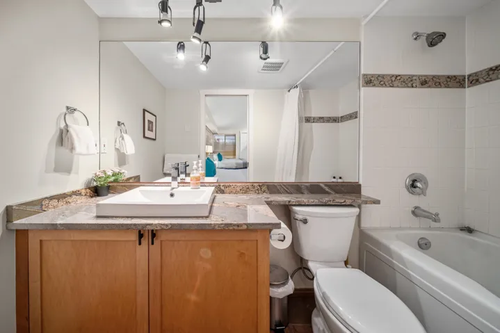 Bathroom featuring shower / bath combo, toilet, and vanity
