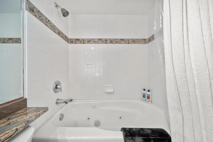 Full bath with a combined bath / shower with jetted tub