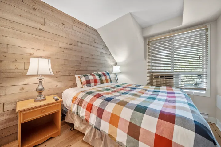 Bedroom featuring wooden walls and wood finished floors