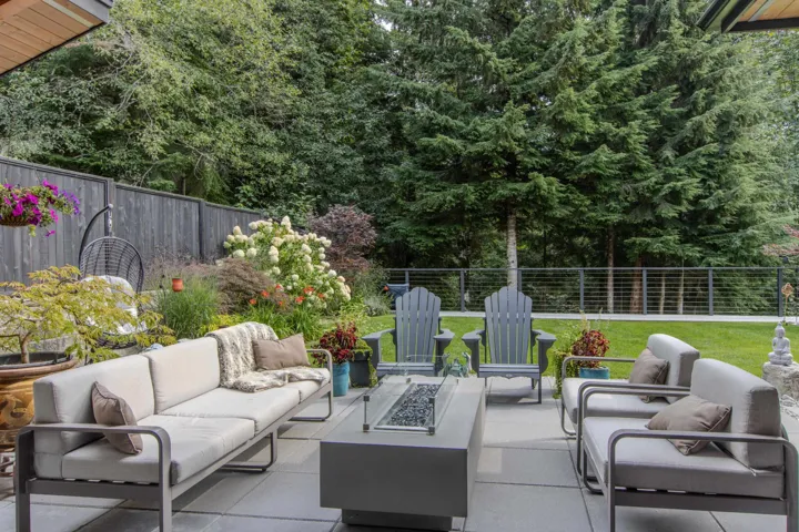 Fenced backyard featuring an outdoor living space with a fire pit and a patio area