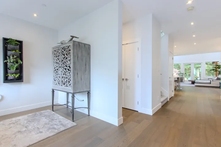Kitchen featuring a kitchen island, high quality appliances, hanging light fixtures, a breakfast bar, and dark wood-style flooring