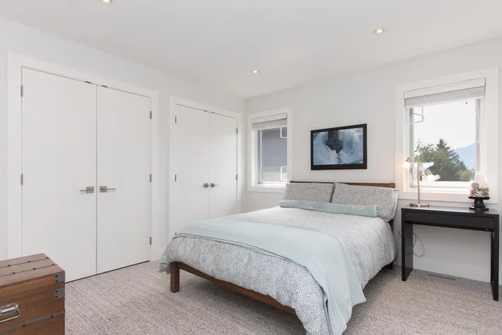 Bedroom featuring multiple closets, light carpet, and recessed lighting