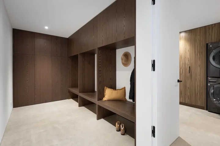 Mudroom with wooden walls, light colored carpet, estacked washer and dryer, and recessed lighting