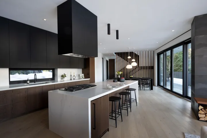 Kitchen with dark cabinets, modern cabinets, a kitchen island, a breakfast bar, and dark wood-style floors