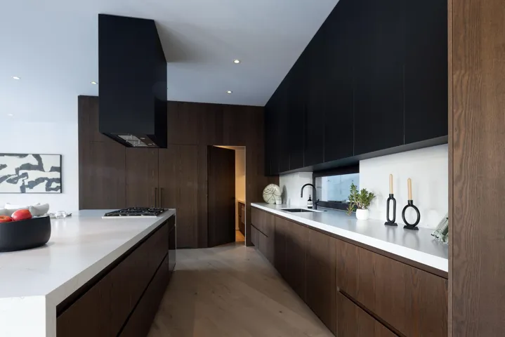 Kitchen with modern cabinets, light wood-type flooring, extractor fan, recessed lighting, and light stone countertops
