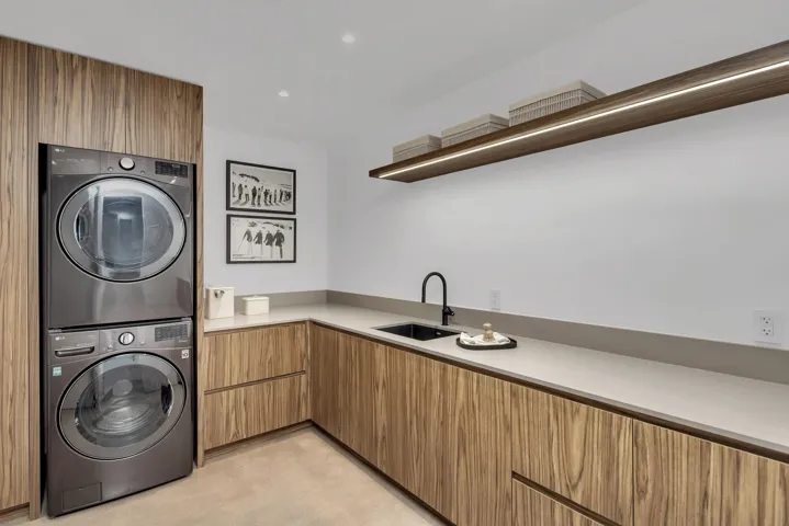 Washroom with stacked washer / dryer, recessed lighting, and cabinet space