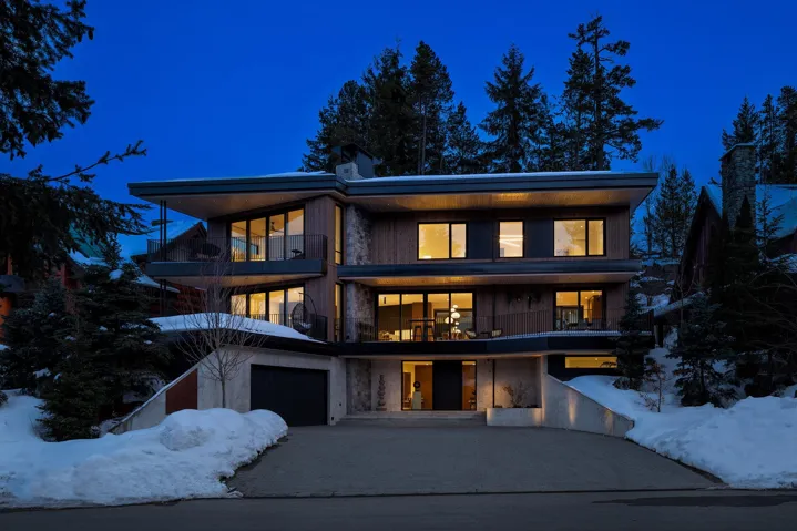 Modern home with a balcony, an attached garage, and driveway