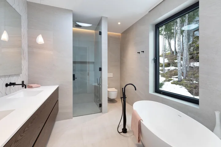Bathroom with tile walls, a freestanding bath, double vanity, a shower stall, and recessed lighting
