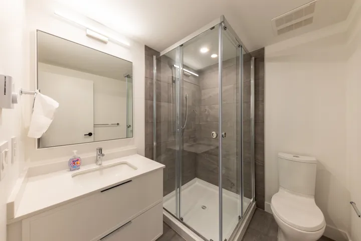 Full bathroom featuring visible vents, a shower stall, toilet, recessed lighting, and vanity