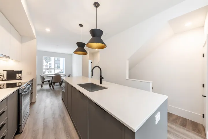 Kitchen with light countertops, a sink, light wood-type flooring, gray cabinetry, and stainless steel electric stove