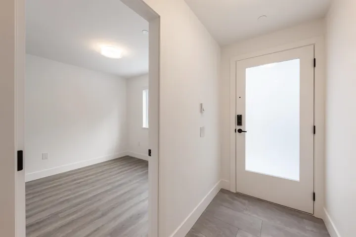 Doorway featuring baseboards and light wood finished floors